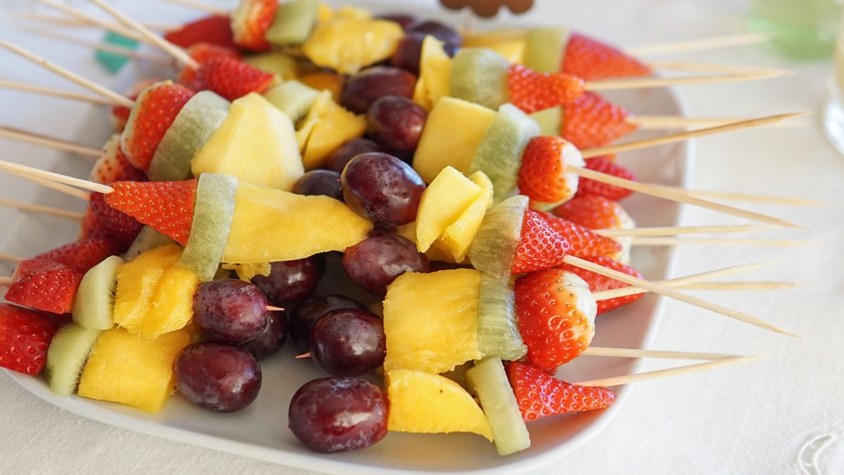 Prato branco com espetadas de fruta para a ementa da festa de aniversário do leão