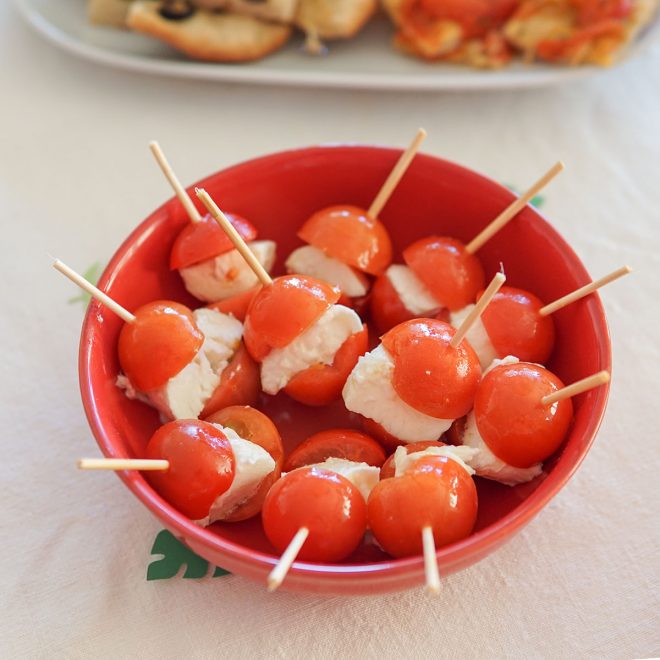 taça vermelha com espetada de tomate cherry e queijo mozarela para a ementa da festa de aniversário do leão