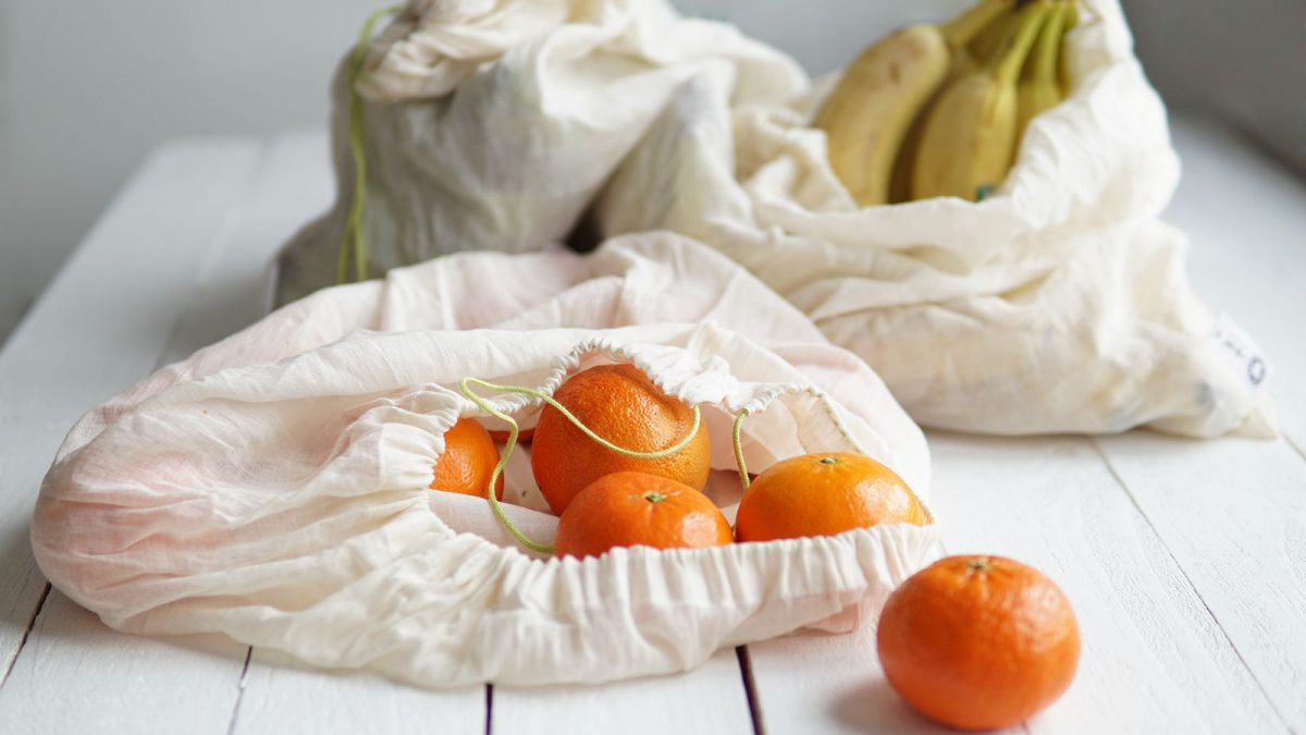 sacos de pano com tangerinas e bananas